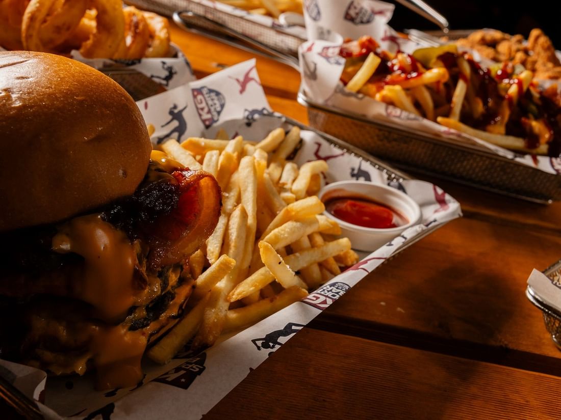 Loaded burgers and French fries served on trays in KG Sport Bar at Mercure Brisbane King George Square