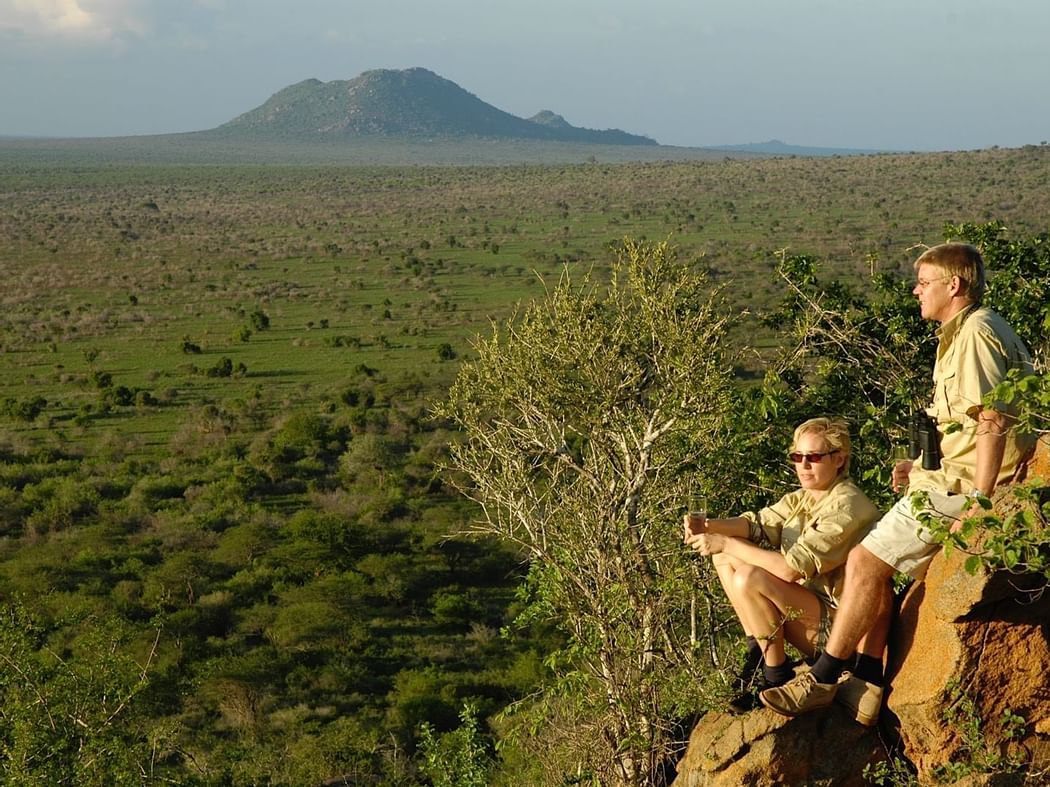 Tourists on a mountain rock near Hotel Kilaguni Serena