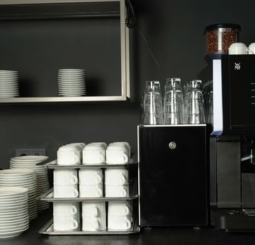 Kaffeemaschine mit Tassen und Tellern im Frühstücksrestaurant des Sylter Hof Berlin.