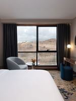 Vanity table facing the bed with a couch near window in Royal Suite at Warwick Al Taif Hotel