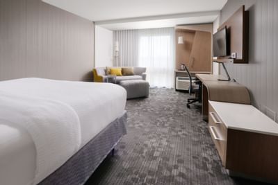 room with bed, small sofa and work desk