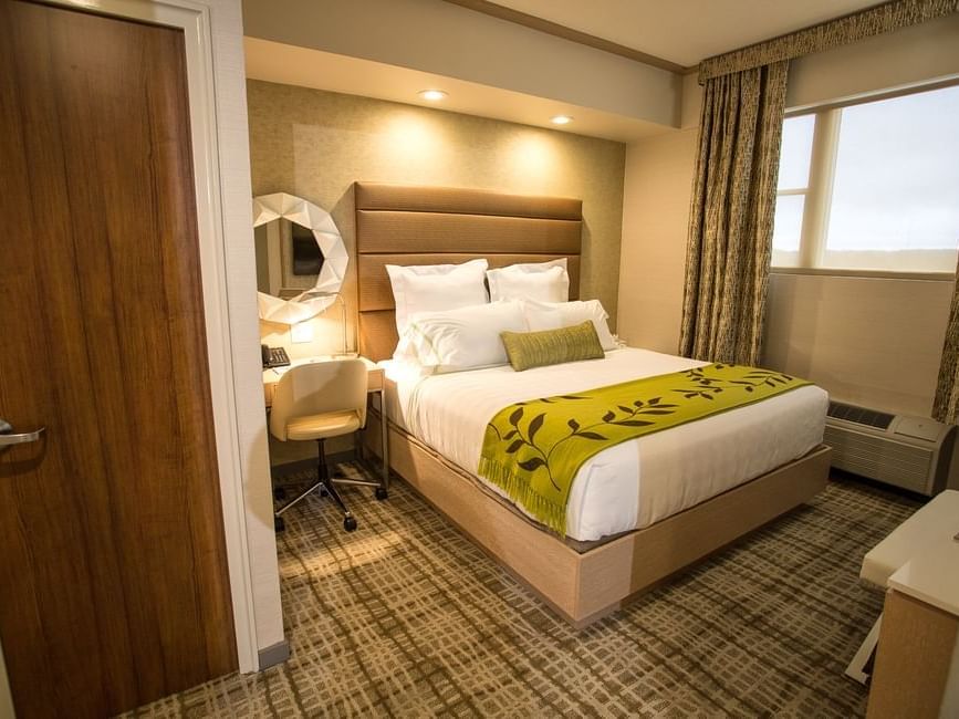 a desk next to a hotel bed