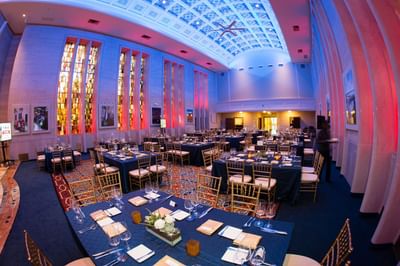 Osgood Building banquet hall at the Bolger Center with multiple tables covered in blue cloth and elegant lighting