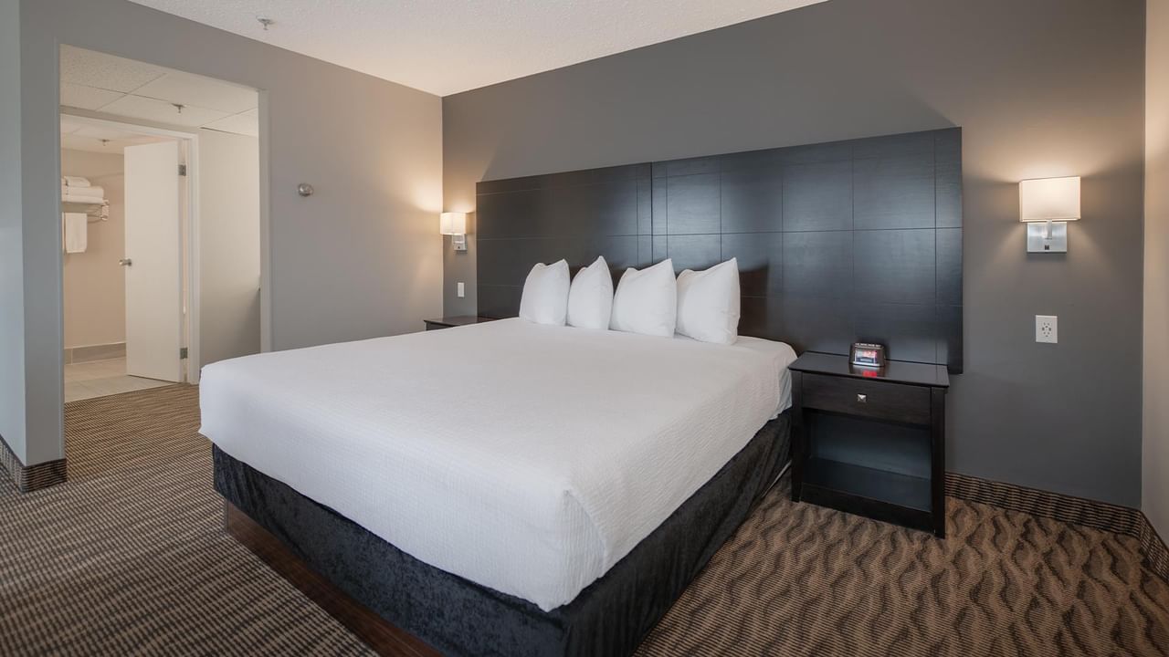 A room with a king bed, nightstands, and gray walls.