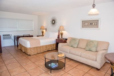 Queen bed with nightstands and seating area in Accessible Suite at Ocean Lodge Boca Raton