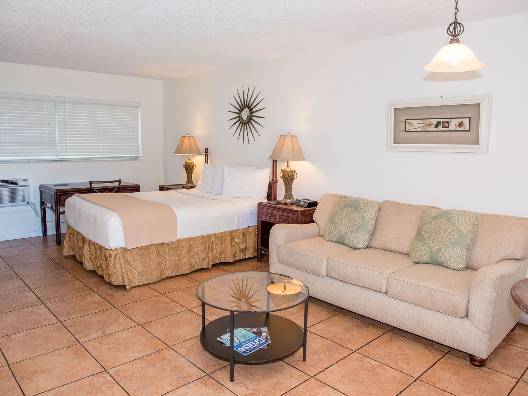 Queen bed with nightstands and living area in Accessible Suite at Ocean Lodge Boca Raton