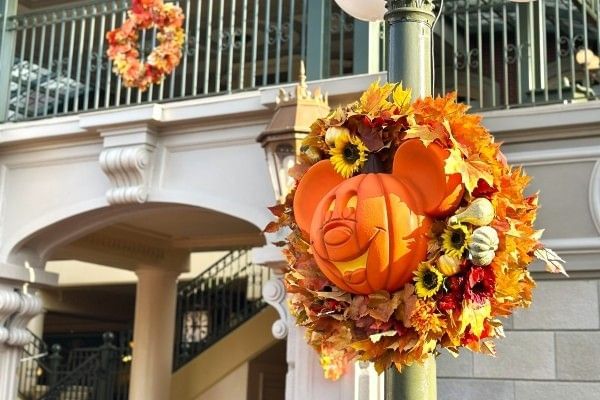 A Mickey Mouse pumpkin in the middle of a fall wreath at Magic Kingdom in Orlando.