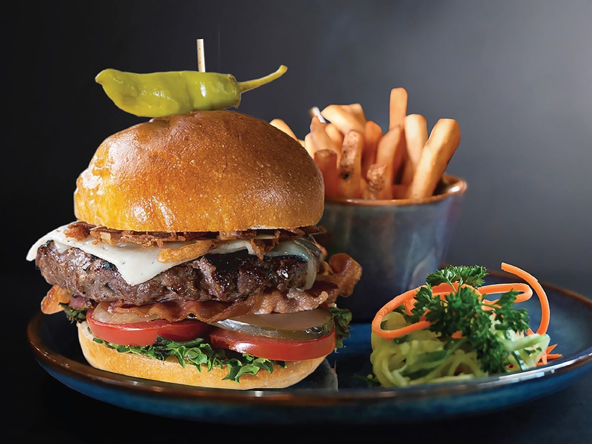 A beef burger served with fries at Hotel Clique Calgary Airport