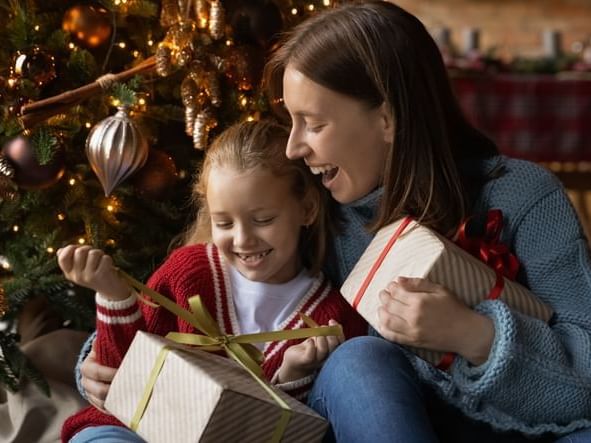 Child and Mother Opening Christmas Gifts