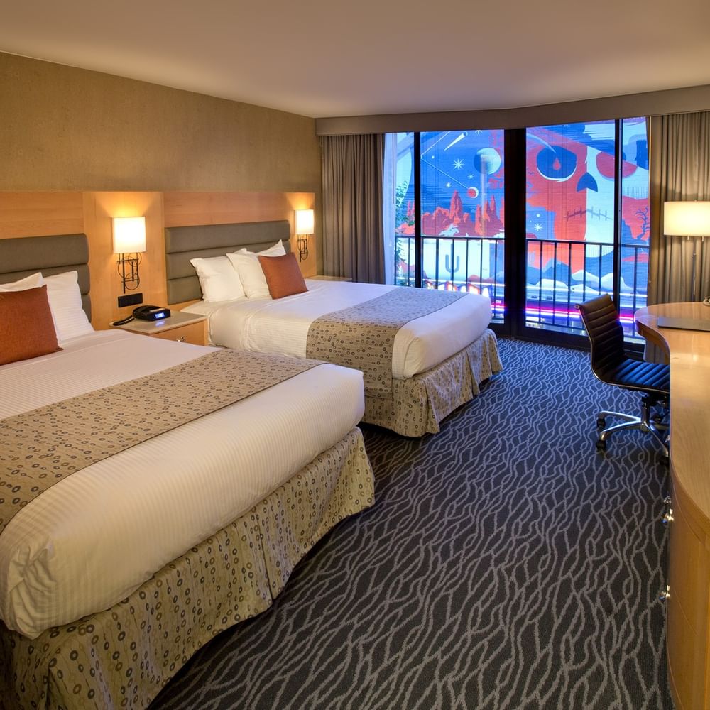 Classic Room with two queen beds facing a TV and desk near a balcony at Warwick Seattle