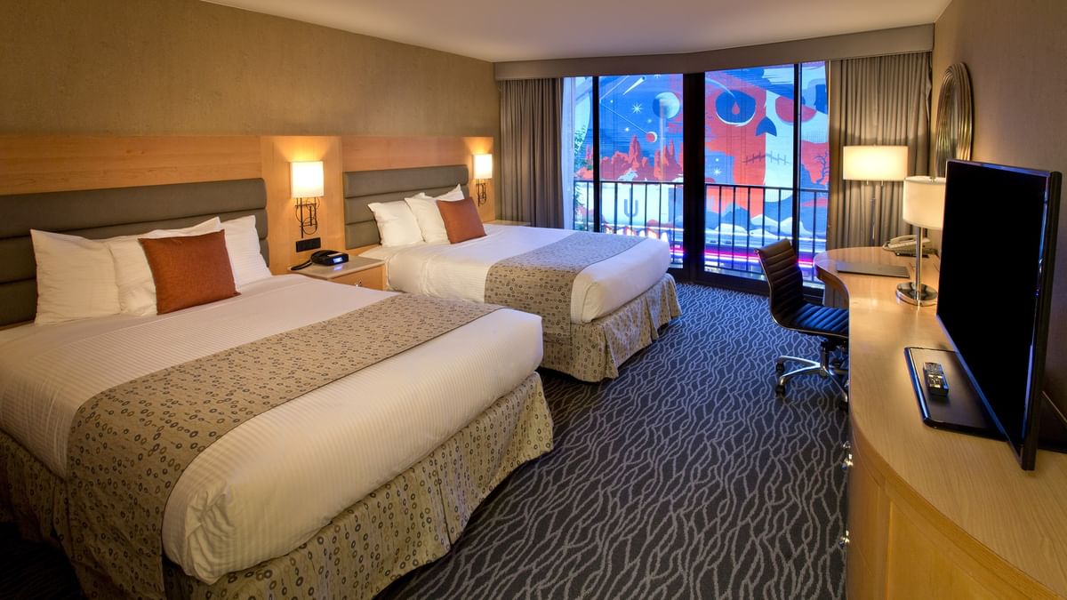 Classic Room with two queen beds facing a TV and desk near a balcony at Warwick Seattle