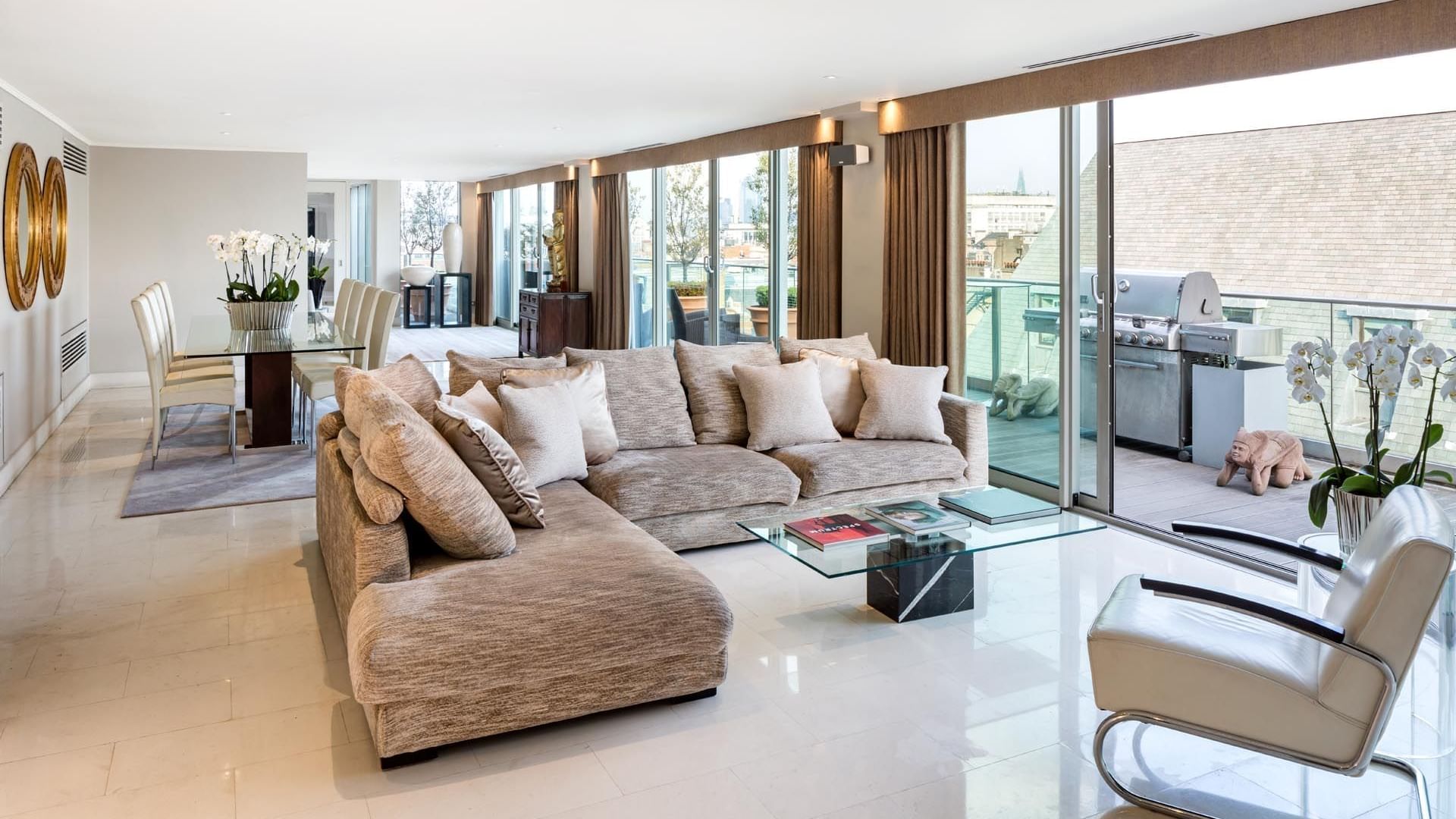 Luxurious open-plan living room with sofa, glass coffee table, and dining area in The May Fair Hotel Penthouse Suite, London