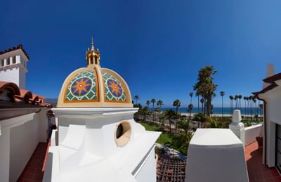Beachside view from the Penthouse suite at Santa Barbara Inn Hotel with sunny shores, palm trees, and a clear blue sky