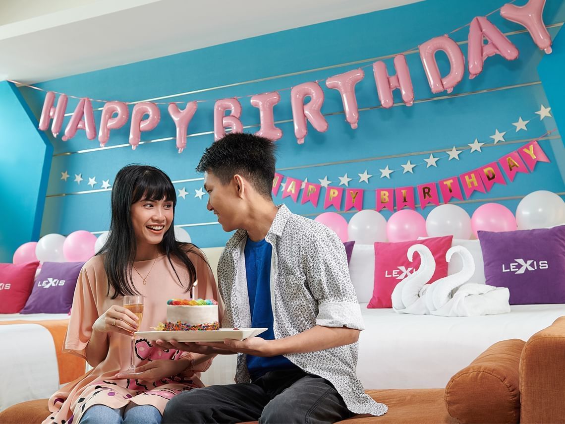 Couple celebrating birthday in romantic decorated hotel room