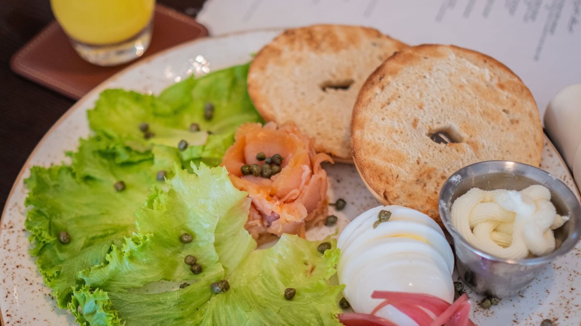 Bagel served with a side of salad & fresh juice at Camp Creek Inn