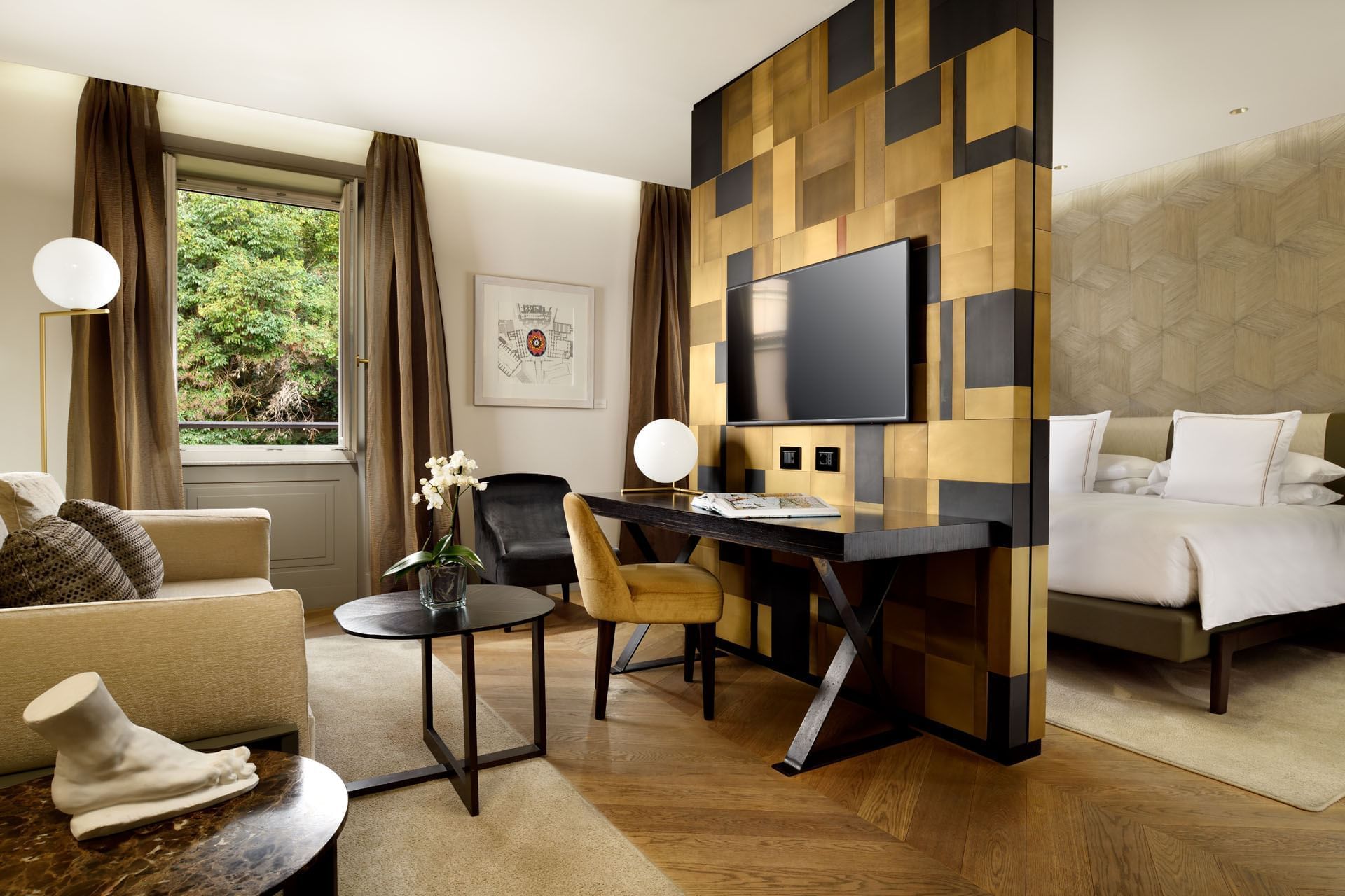 Comfy bed, TV, sofa and work table in Deluxe suite at Rome Luxury Suites