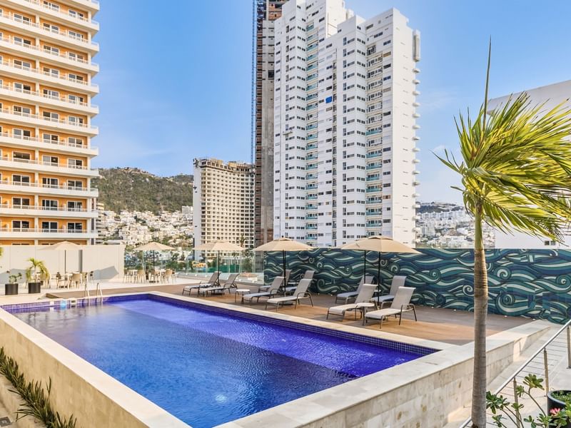 Outdoor pool area with sunbeds at One Hotels