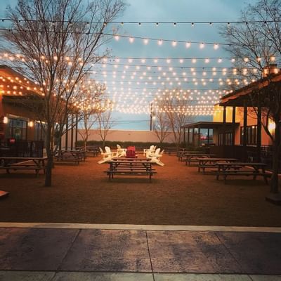 outdoor area with picnic tables and hanging lights