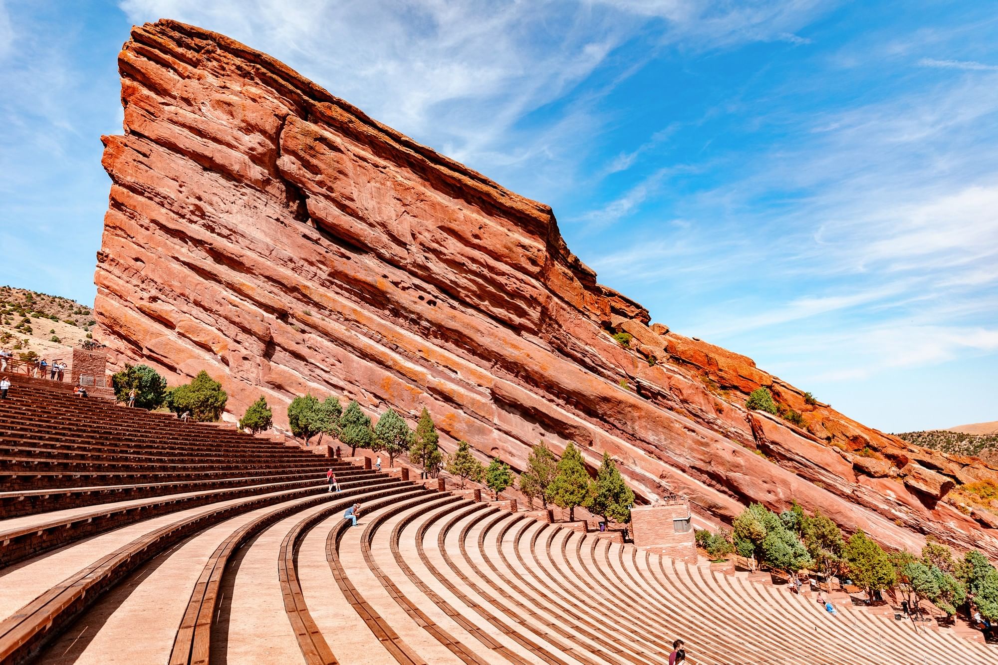 Red Rocks Park by a massive red rock formation under a bright blue sky near Warwick Denver