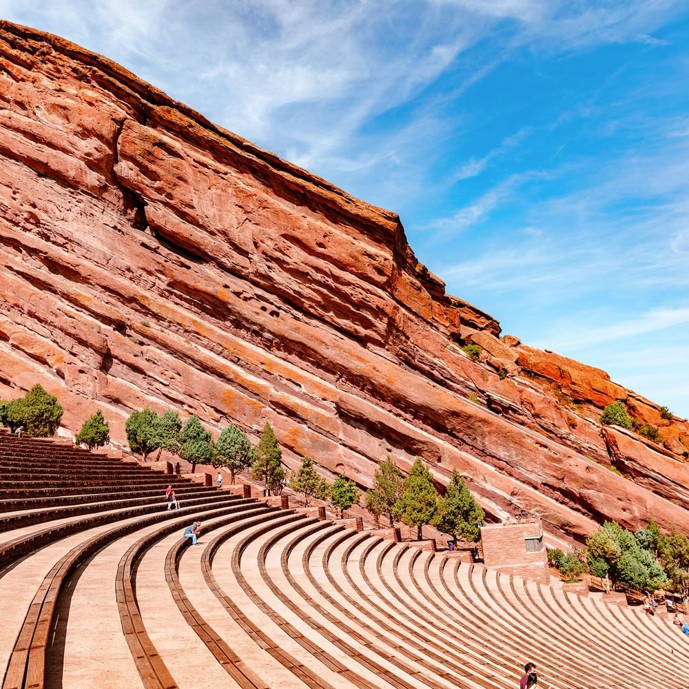 Red Rocks Park by a massive red rock formation under a bright blue sky near Warwick Denver