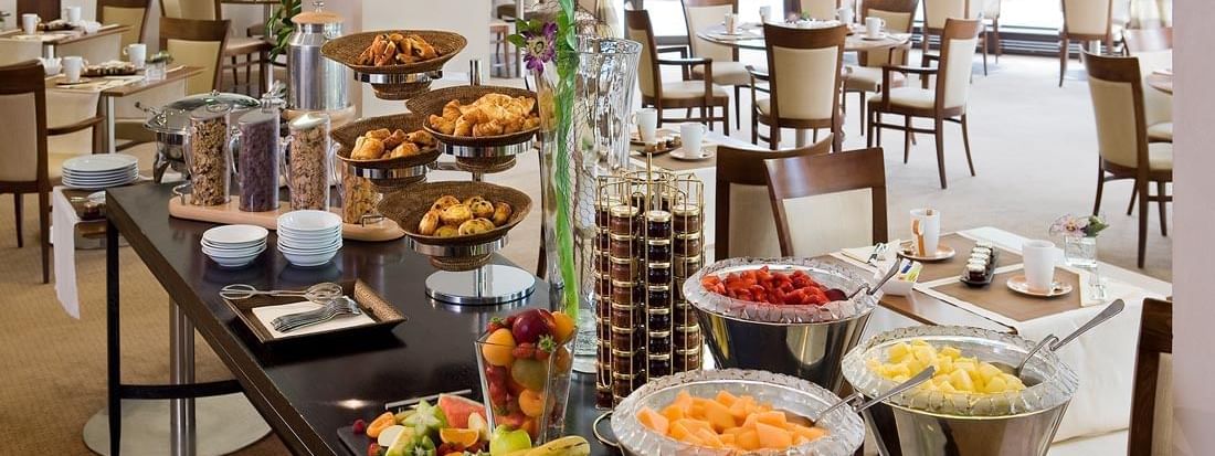 Elegant breakfast buffet in a bright, spacious dining area in the Roseraie Room at Warwick Reine Astrid - Lyon