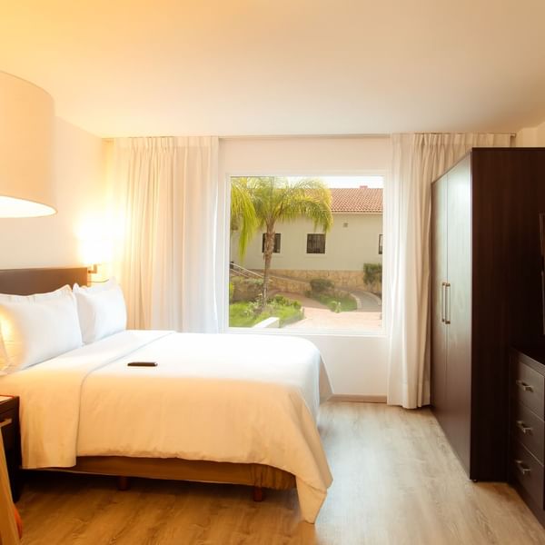 Closeup of king bed in Junior Suite with view at Fiesta Inn