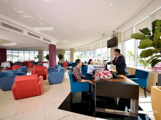 Receptionist passing room key to customers at Captain Lounge, Le