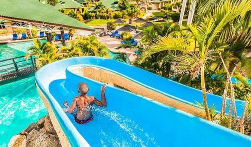 Boy riding down the waterslide on a sunny day at Tokatoka Resort