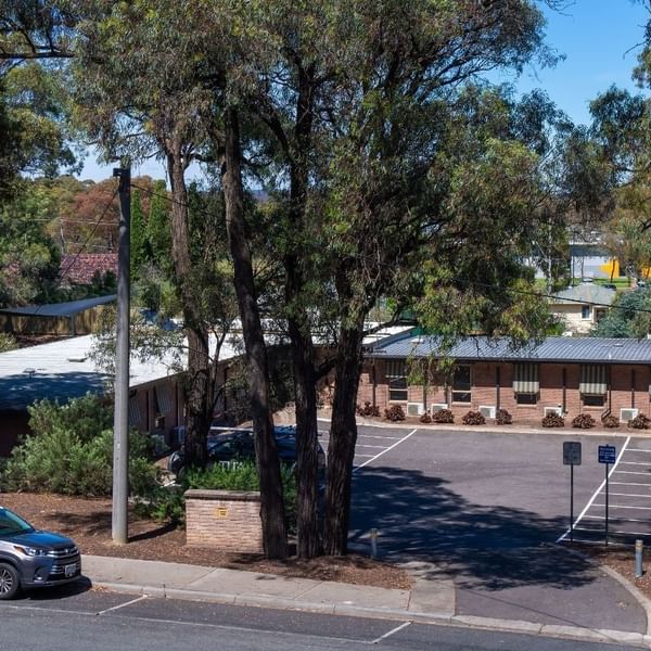 Car parked in front of La Trobe University - Orde House surrounded by trees.
