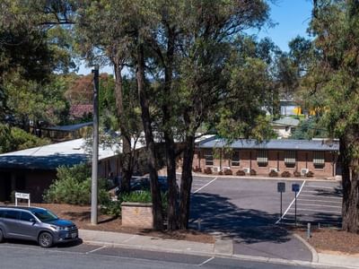 Car parked in front of La Trobe University - Orde House surrounded by trees.