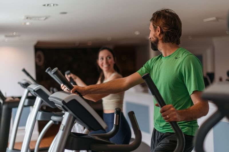 Man and woman exercising on elliptical machines in the gym at Mountain View Grand Resort & Spa
