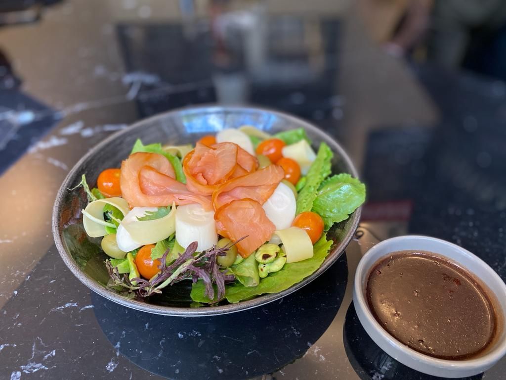 Ensalada con salmón y salsa en The Glass Restaurant de Hoteles Cumbres en Vitacura.