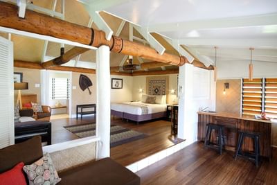 Beachfront Bures room with exposed beams, hardwood floors, and traditional furnishings at Musket Cove Island Resort & Marina