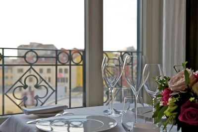 Dining table set up with fresh flowers, wine glasses & plates in a restaurant at Grand Visconti Palace