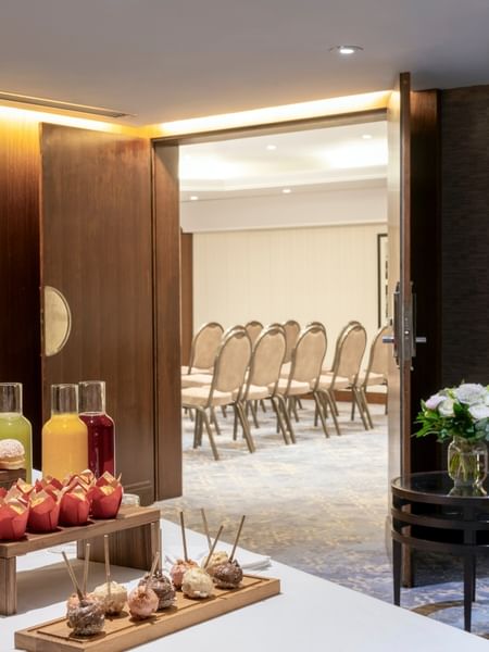 Juice carafes and pastries by a bowl of fruit under a portrait in Seminars & Banquets at Warwick Paris Champs Elysées