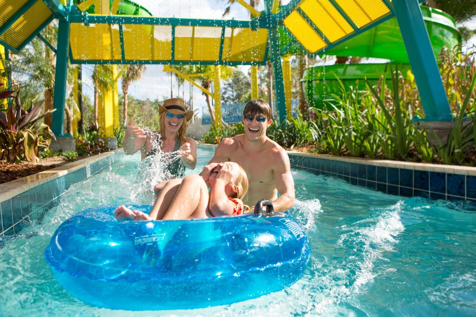 Kid on an inflatable ring with parents in a pool of Surfari Water Park at The Grove Resort & Water Park