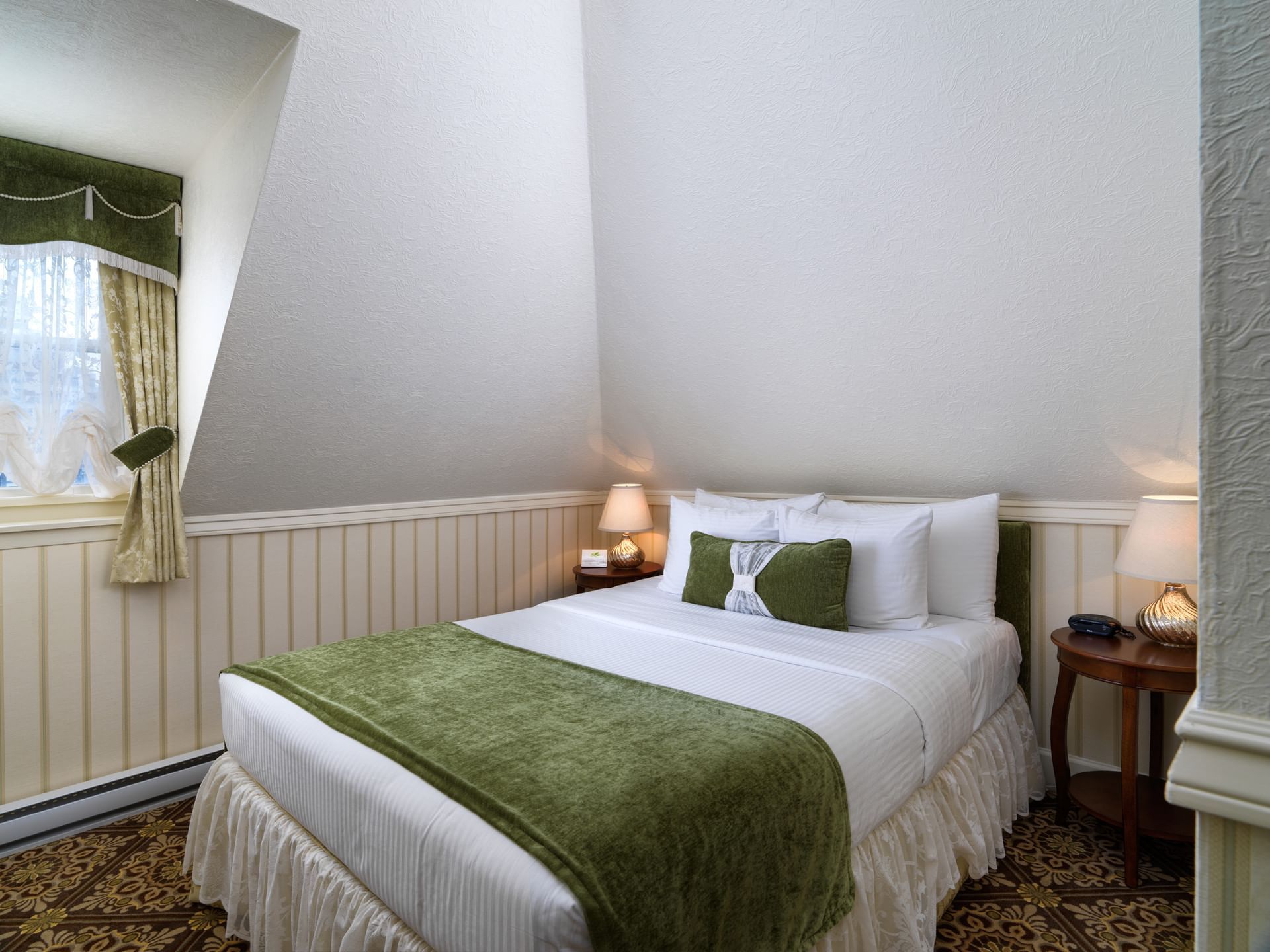Queen bed with nightstands in Emily Carr Suite at Pendray Inn & Tea House
