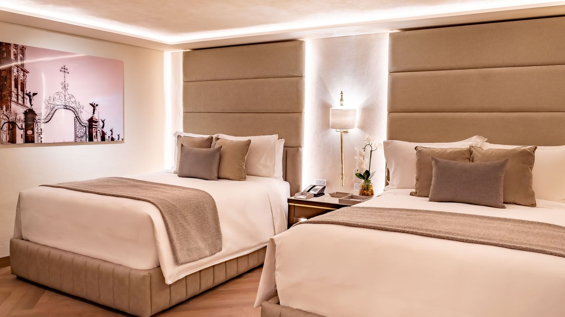 Two queen deluxe beds with pillows and artwork on the wall at Quinta Real Puebla in Heroica Puebla de Zaragoza.