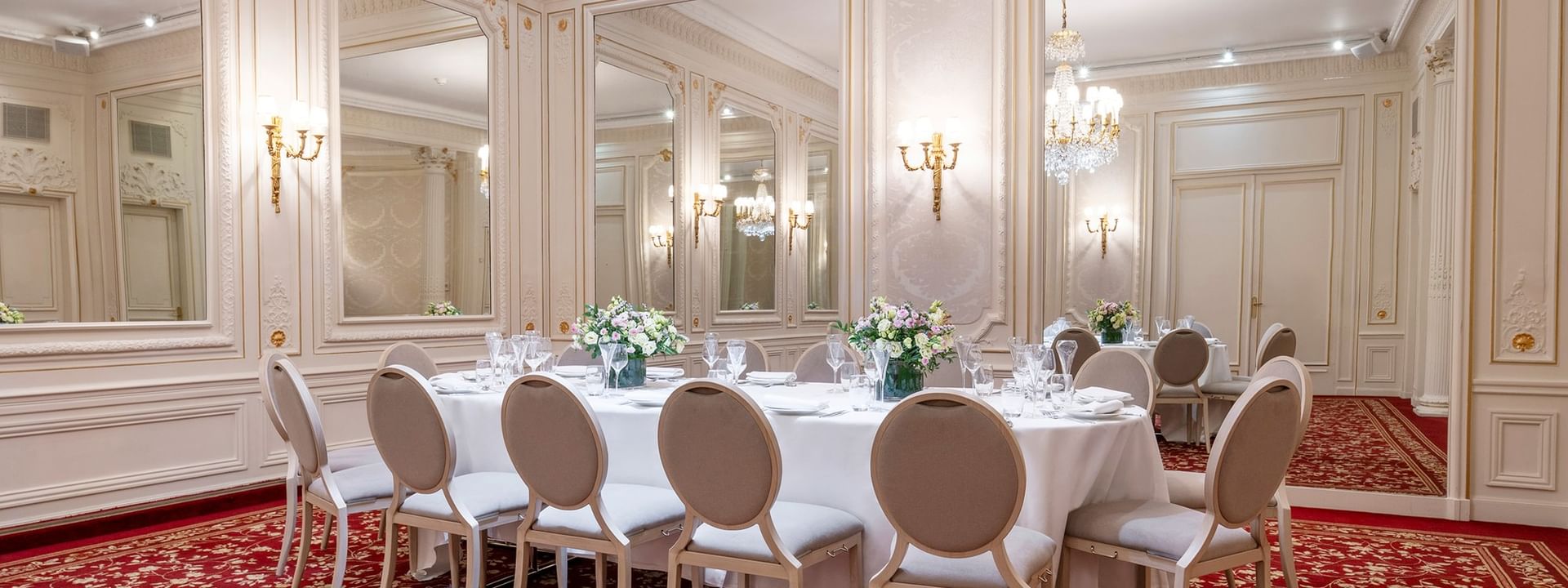 Banquet table, with chairs under a large chandelier in Capucines Meeting Room at Hotel Westminster Paris