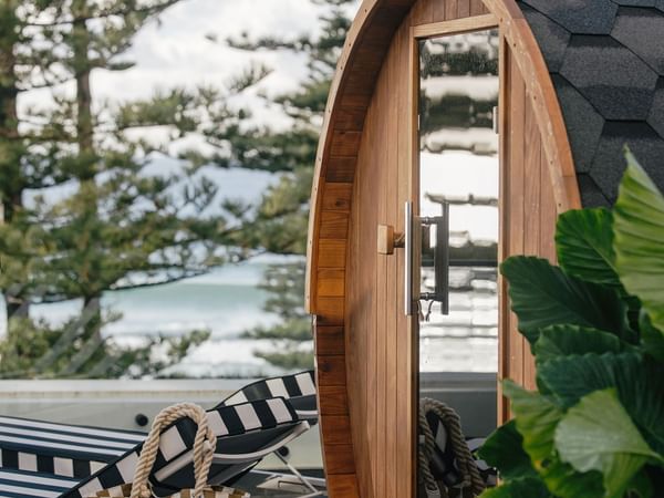 Wellness Suite King at Elysium Hotels with barrel sauna beside striped lounger, showcasing relaxing places to stay in manly
