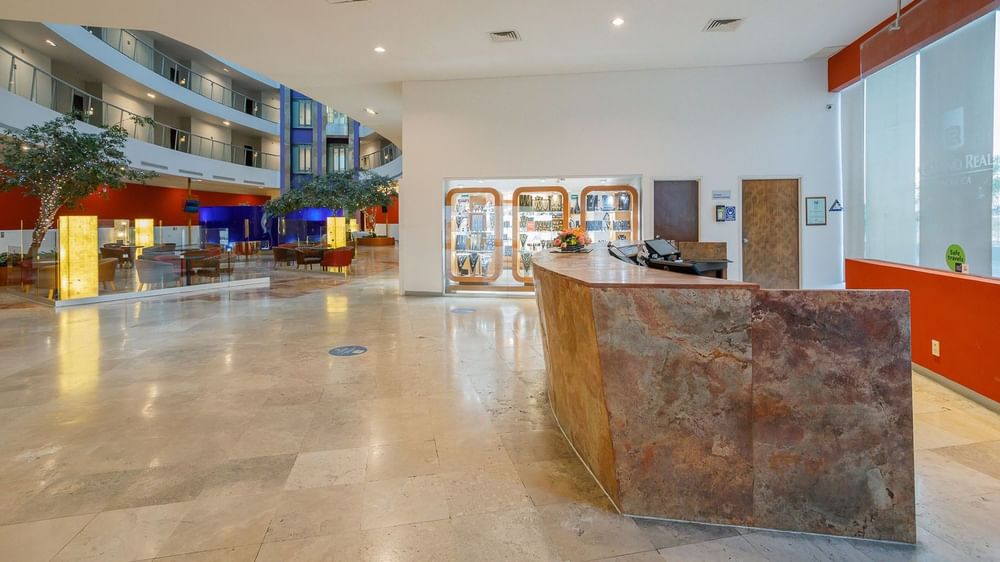 Wide view of the reception area at Camino Real Pachuca, showing the stone desk and gift shop in the background