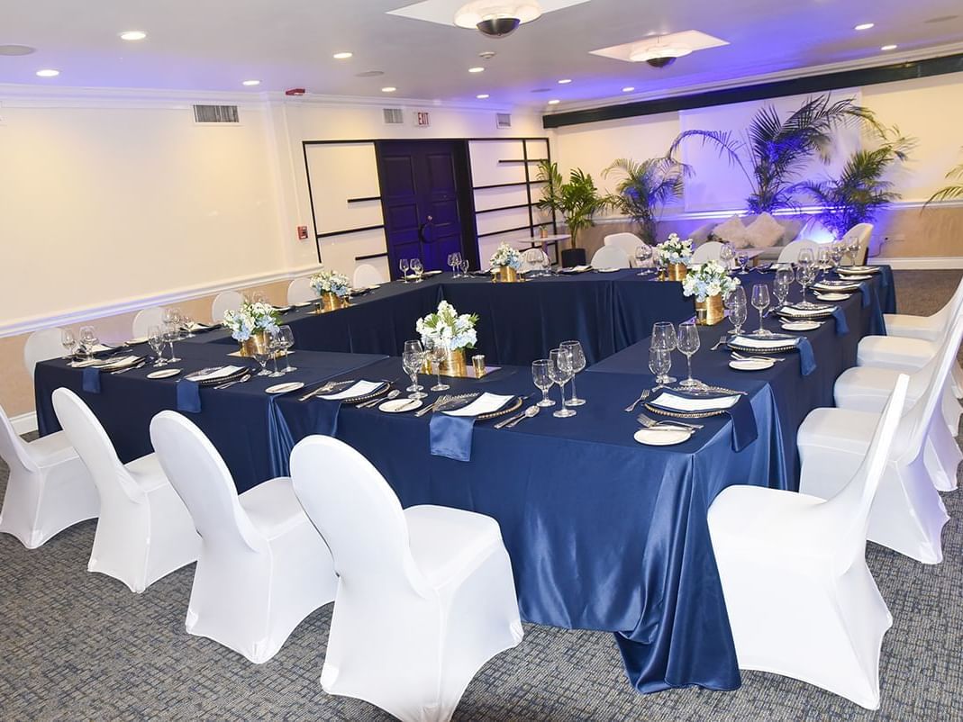 A banquet room with elegant blue and white tablecloths in Somerset Suite at Courtleigh Hotel & Suites