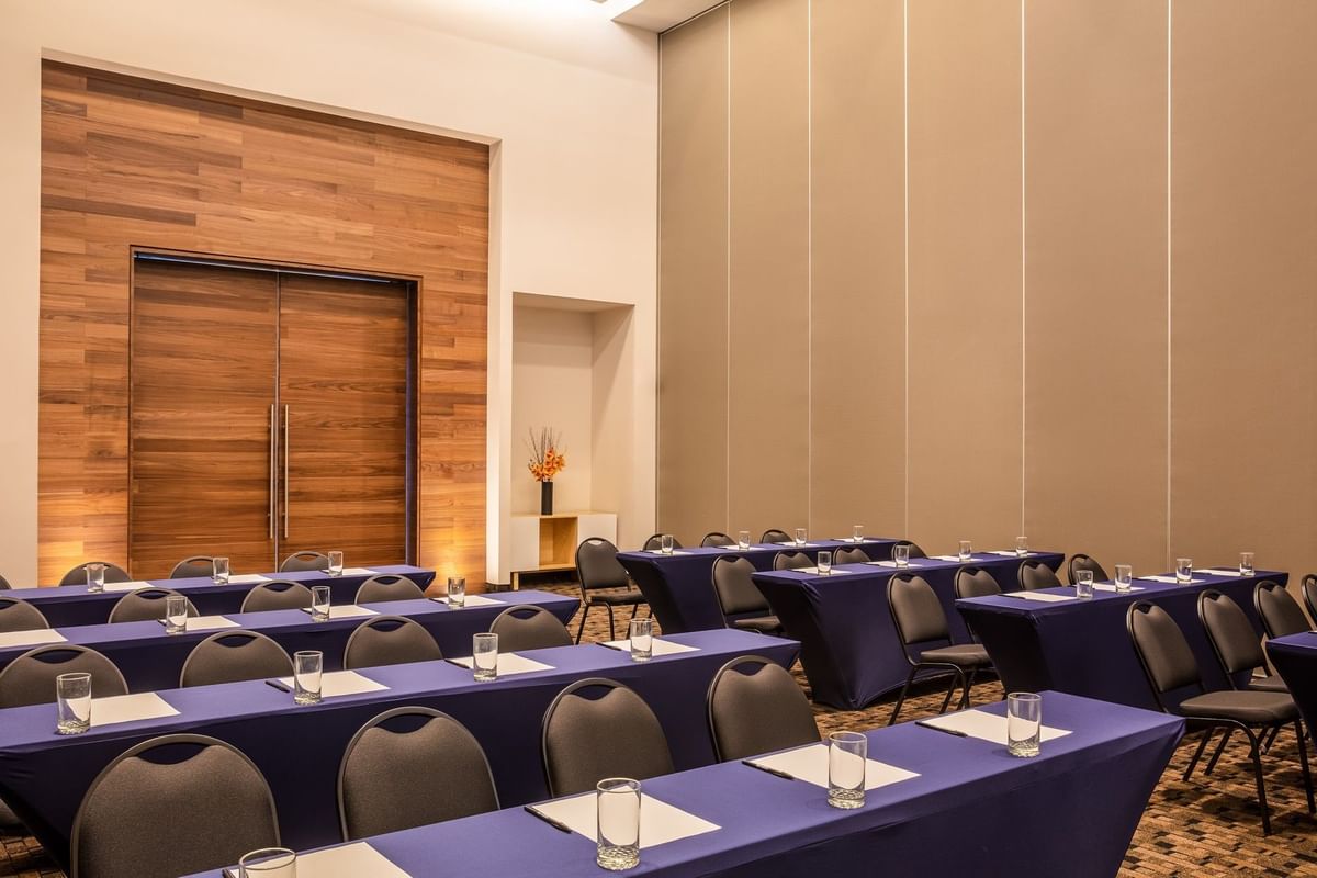 Sala de conferencias preparada para reunión con mesas y sillas azul marino en Fiesta Inn