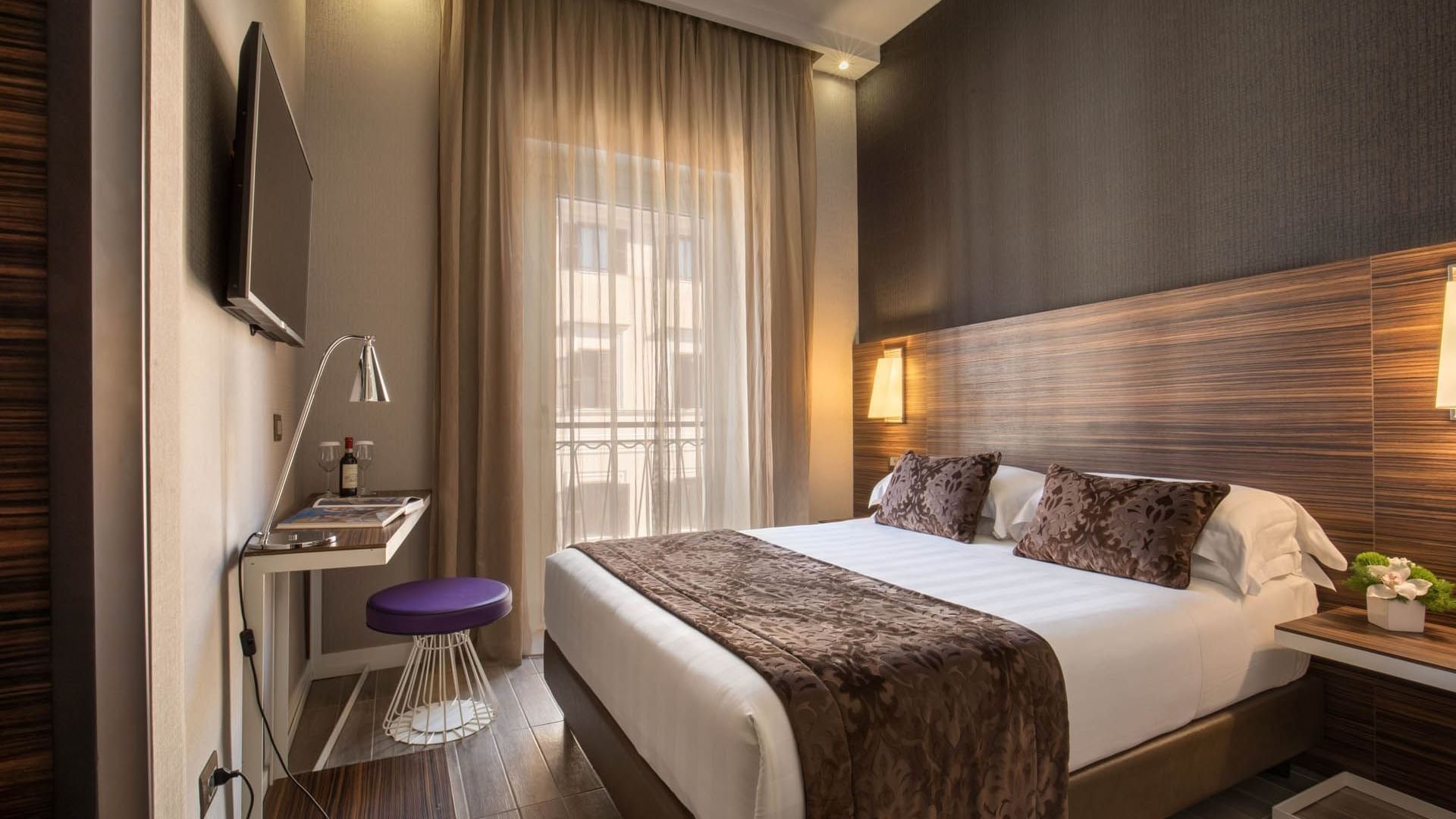 Classic Room featuring a queen bed with pillows, a sleek desk with a purple stool, and curtains at The Republic Hotel