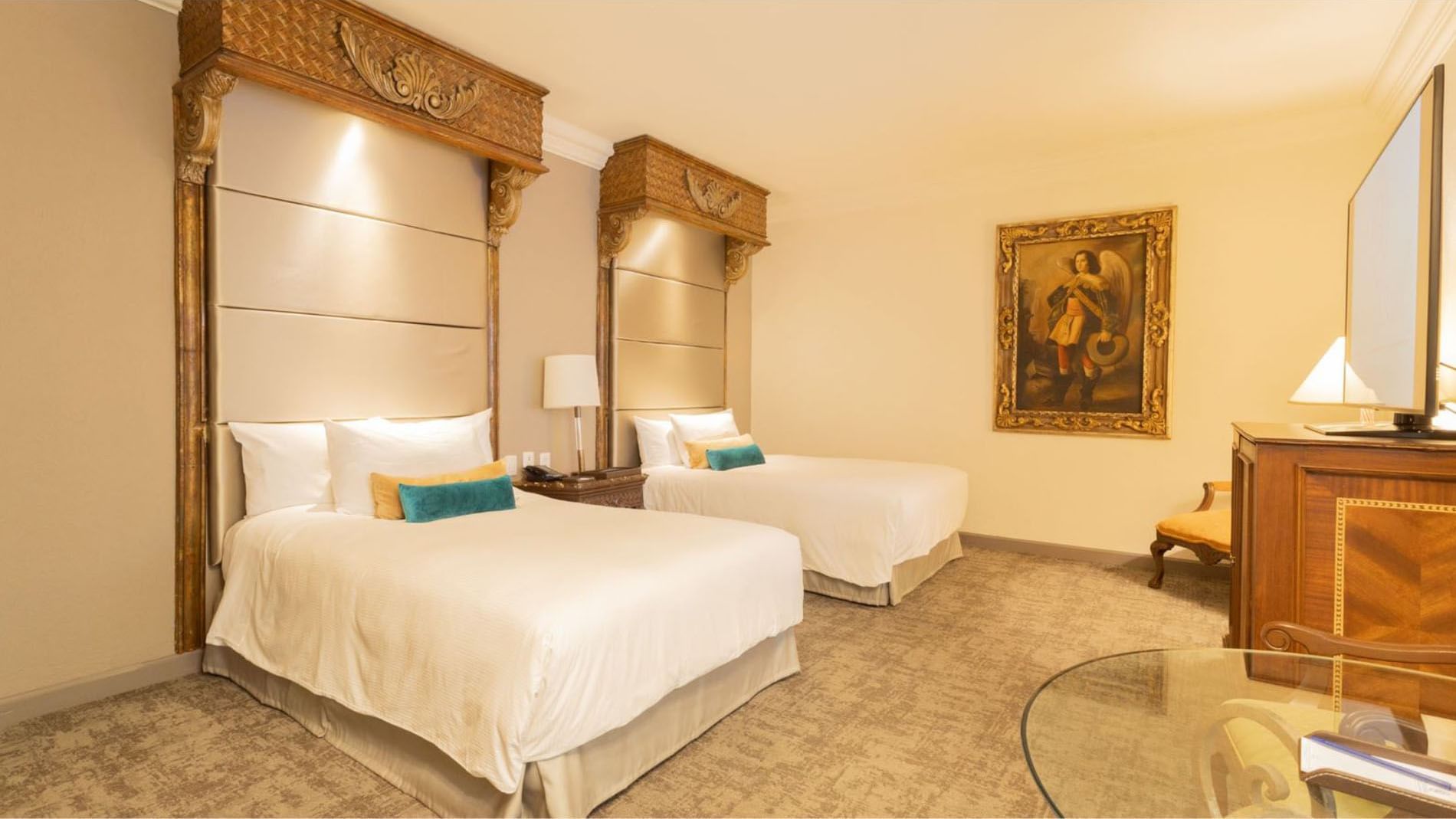 2 Double Master Suite with two beds, classic art, and a small glass-top dining table at Quinta Real Monterrey