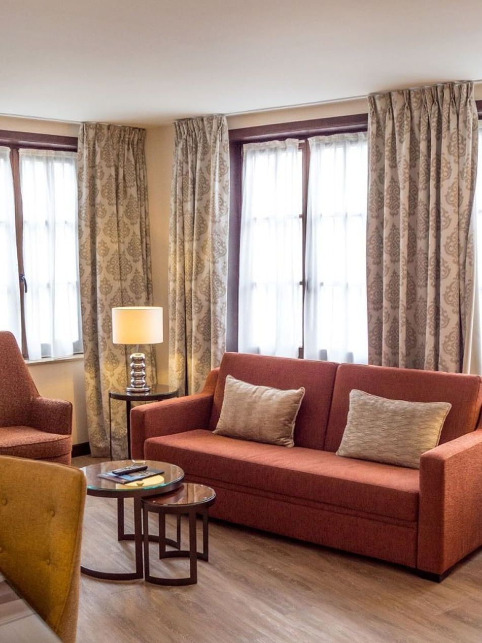 Junior Suite Privilege View living area featuring plush sofa with coffee table near window at Warwick Grand Place Brussels