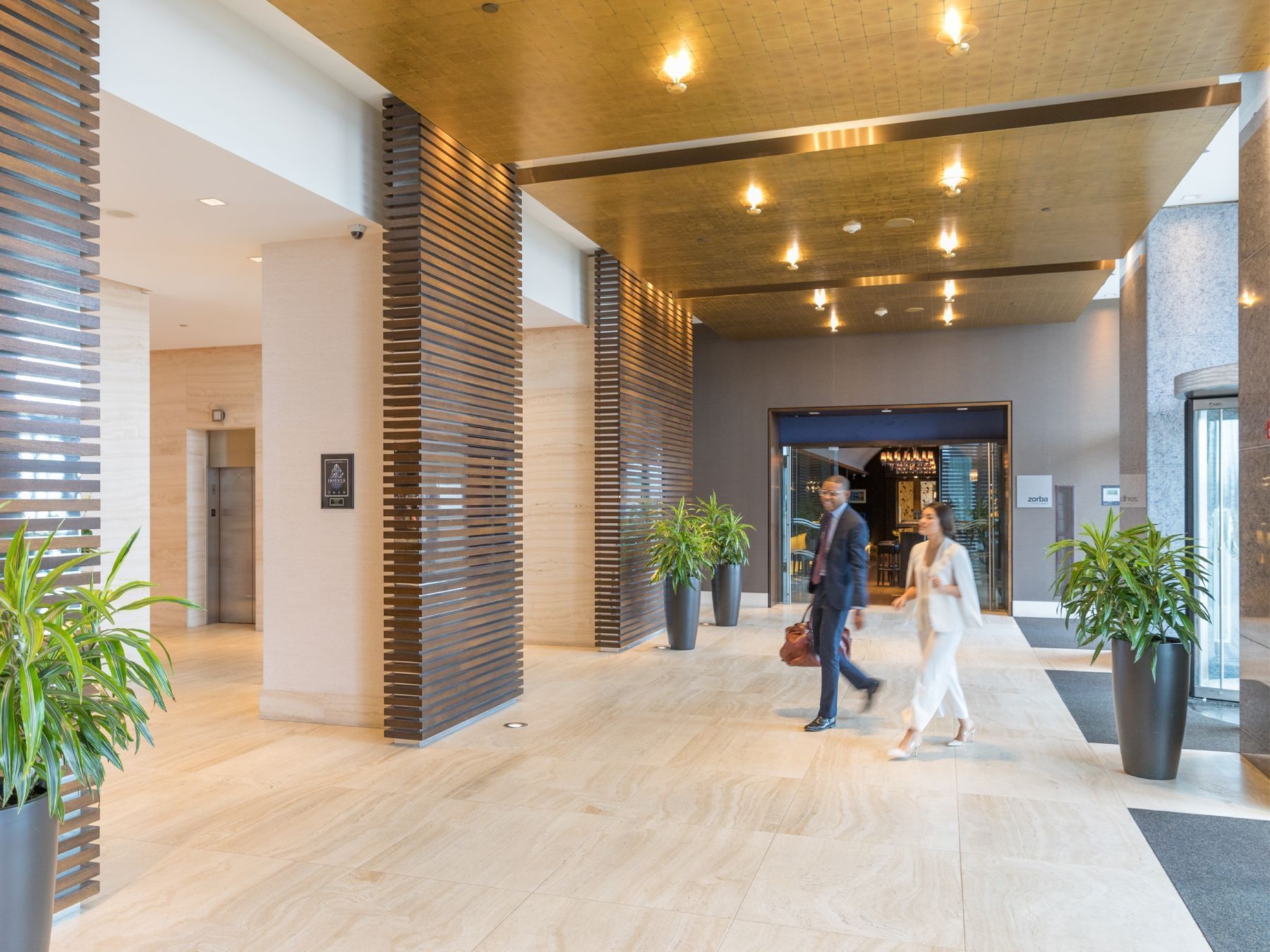 Couple walking in the Hotel Arista lobby, enjoying the AAA Member Rate special package in Naperville, Illinois.