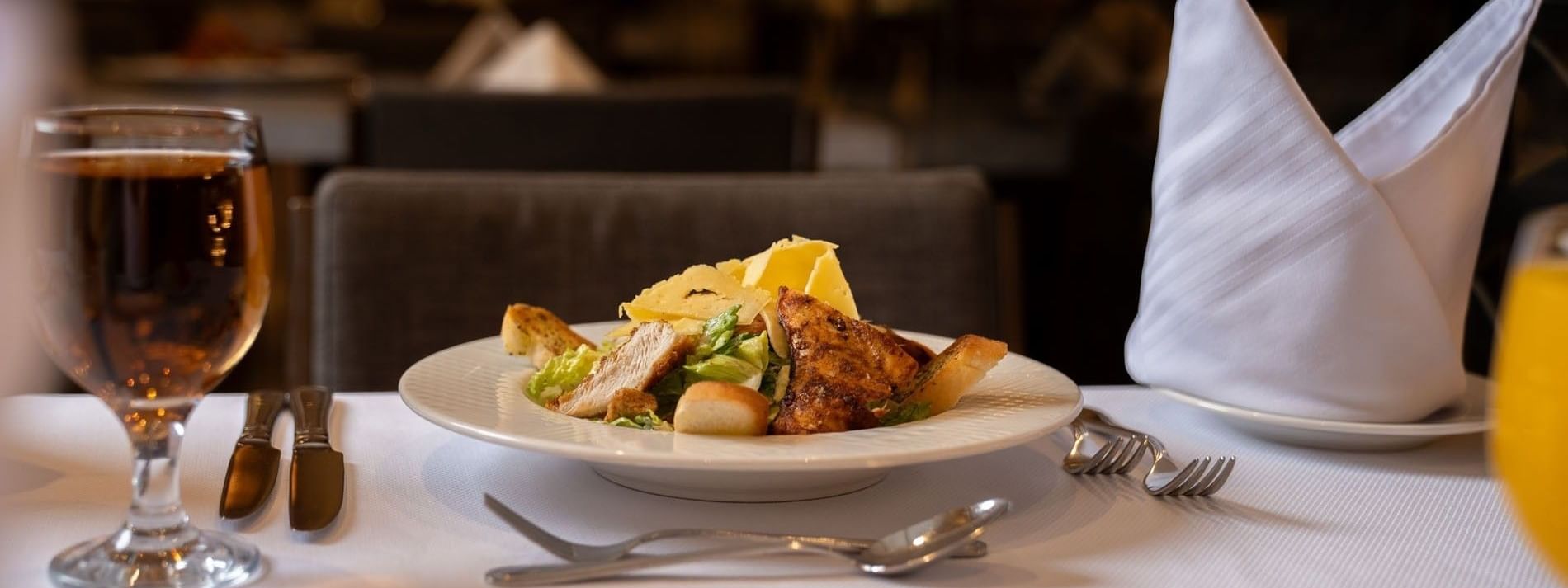 Fresh Caesar salad with grilled chicken served on a white dinner plate in Al Firdous Restaurant at Saja Warwick Madinah 