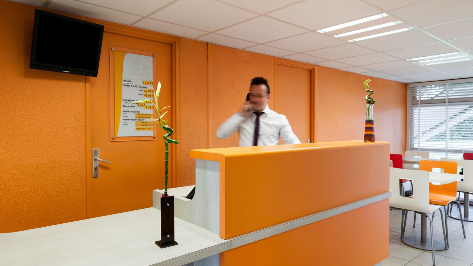 A receptionist answering the phone at Hotel Rouen South Oissel