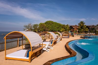 Outdoor pool with sunbeds by sea at Hotel Isla Del Encanto